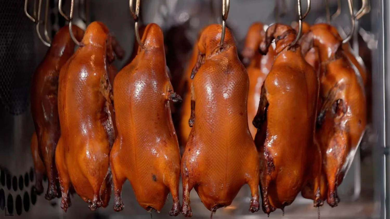 A line of roasting units in production, each loaded with whole ducks