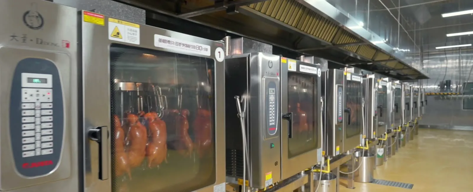 A line of roasting ovens loaded with whole ducks